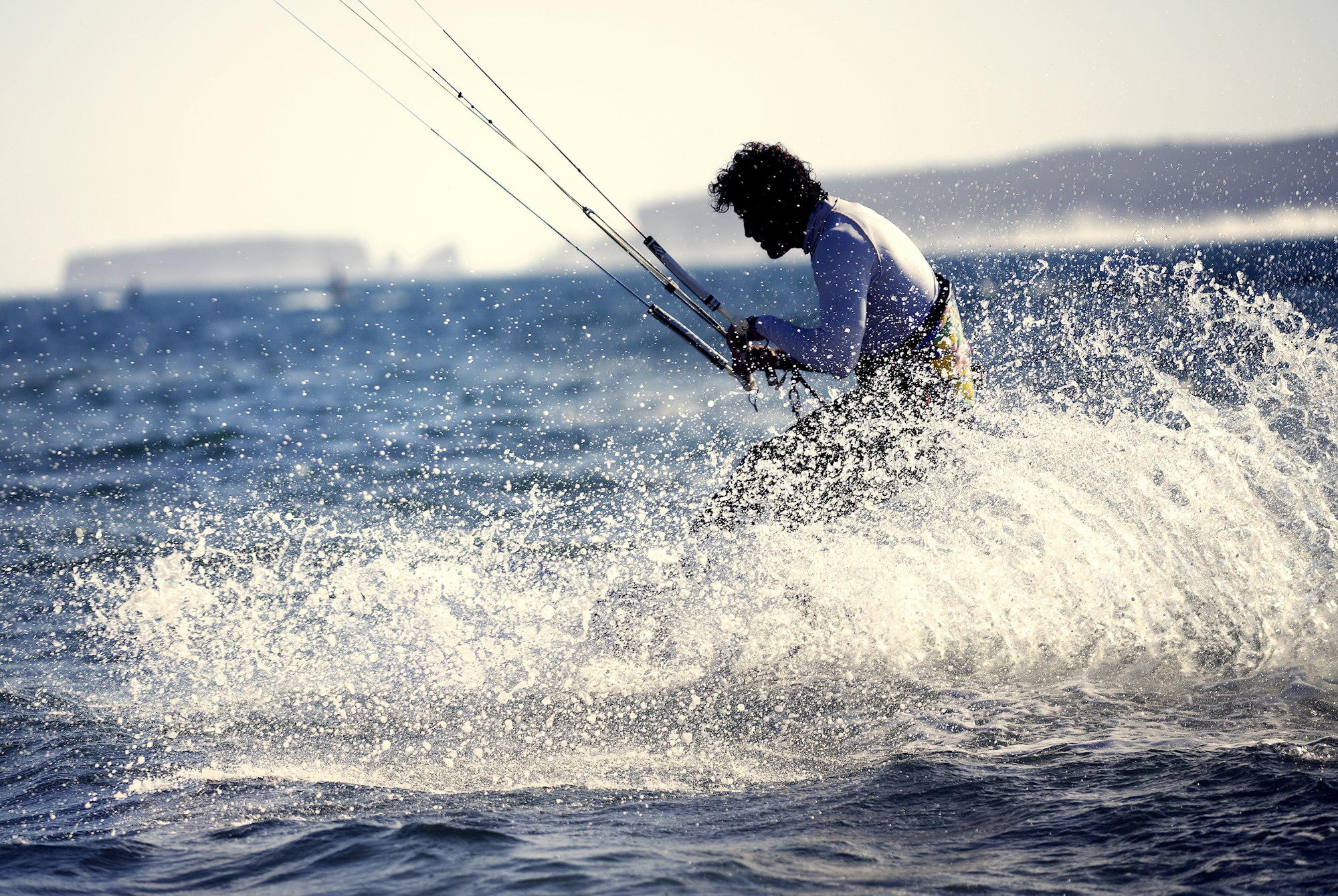 Side vie of man kitesurfing in the ocean.